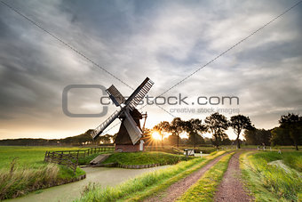 morning sunshine behind old Dutch windmill in summer