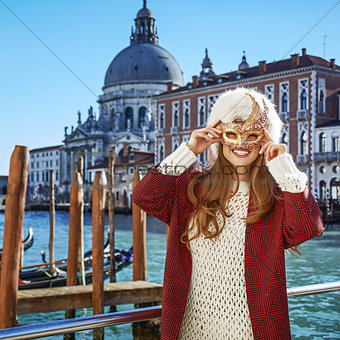 smiling elegant woman in Venice, Italy wearing Venetian mask