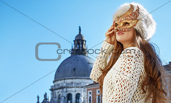 woman looking into the distance while wearing Venetian mask