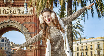 happy woman near Arc de Triomf walking on parapet in Barcelona