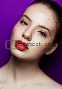 Beautiful woman with makeup red lips on purple background