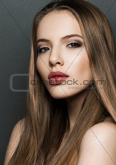Beautiful woman model portrait with long hair on dark background