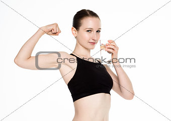Young fitness girl drinking healthy water in gym