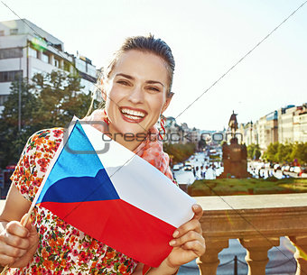 smiling woman on Vaclavske namesti in Prague showing flag