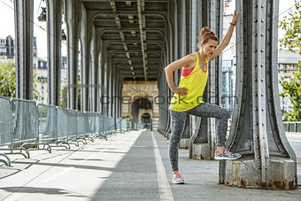 woman jogger relaxing after workout on Pont de Bir-Hakeim bridge