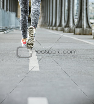 Closeup on woman jogger running on Pont de Bir-Hakeim bridge