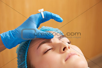 Permanent make-up wizard makes eyebrow correction procedure.