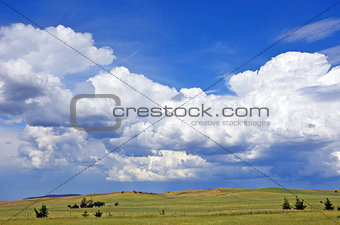 Cloudscape over rolling green hills