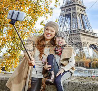 mother and child tourists taking selfie on embankment In Paris