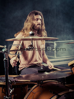 Young man with long hair playing drums