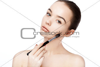 Beautiful girl holding makeup brush foundation