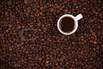 Coffee beans background with white cup