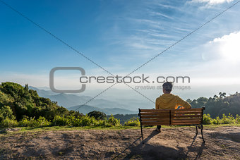 Traveler man siting wooden bench with Mountains