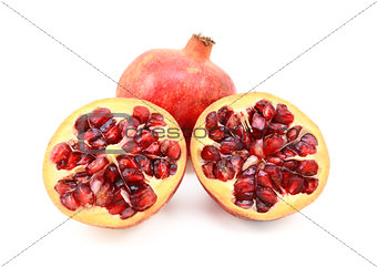Whole red pomegranate and two cut halves showing seeds