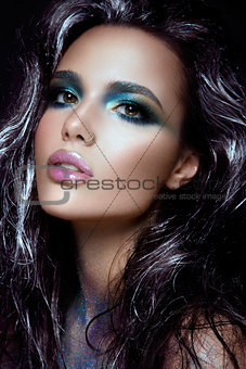 Beautiful girl with blue glitter on her face