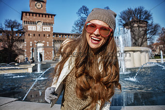 Portrait of happy trendy traveller woman in Milan, Italy