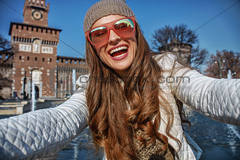 happy trendy traveller woman in Milan, Italy taking selfie
