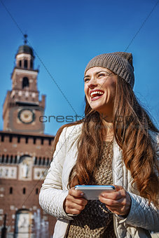 smiling young woman in Milan, Italy writing sms