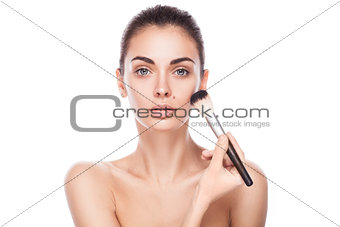 closeup portrait of young adult woman with brush for makeup