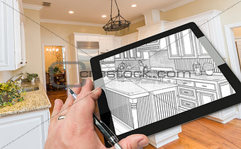 Hand on Computer Tablet Showing Drawing of Kitchen Photo Behind