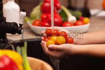 Making a vegetables salad, washing ingredients - cherry tomatoes