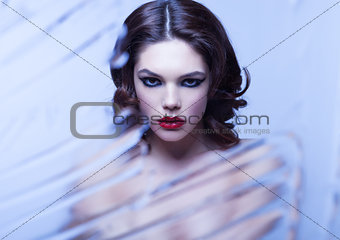 Beauty woman model with makeup through mirror