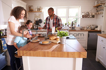 Family At Home Eating Breakfast In Kitchen Together