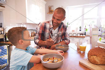 Father And Son At Home Eating Breakfast In Kitchen Together