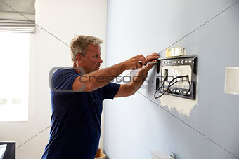 Man Fitting Bracket For Flat Screen TV Onto Wall