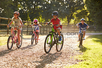 Four Children On Cycle Ride In Countryside Together