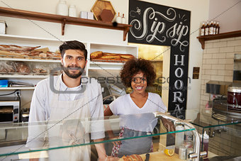 Mixed race couple behind counter at sandwich bar, close up