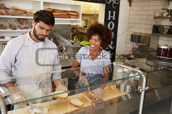 Mixed race couple work behind the counter at a sandwich bar