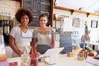 Two women behind the counter at a coffee shop, wide angle