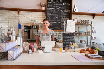 Woman ready to serve behind the counter at a coffee shop