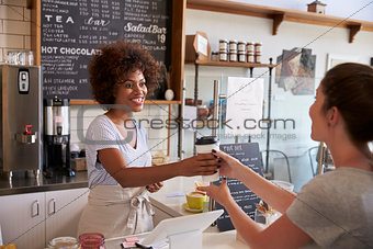 Waitress serving customer over the counter at a coffee shop