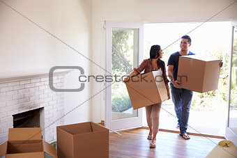 Couple Carrying Boxes Into New Home On Moving Day