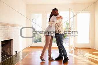 Excited Couple Hugging In New Home On Moving Day