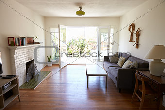 Interior Of Modern Lounge With Open French Windows To Garden