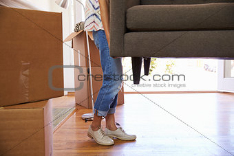 Close Up Of Woman Carrying Sofa Into New Home On Moving Day