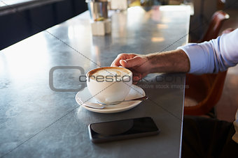 Close Up Of Man With Mobile Phone On Counter Of Coffee Shop