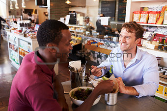 Two Men Enjoying Lunch In Delicatessen Restaurant
