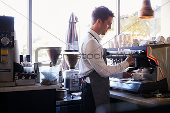 Barista Making Coffee In Delicatessen Using Machine