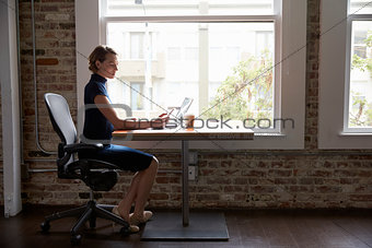 Businesswoman Working On Laptop And Checking Mobile Phone