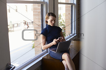 Businesswoman Working On Laptop And Checking Mobile Phone