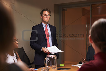 Young white businessman addresses team at meeting, low angle