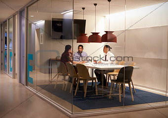 Three people in meeting cubicle at a big corporate business