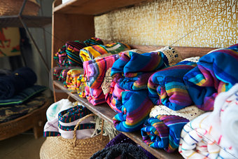 Colourful blankets displayed on shelves in a store, close up