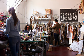 Multi ethnic team working together in clothes design studio
