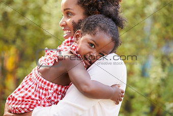 African American mother embracing with baby daughter