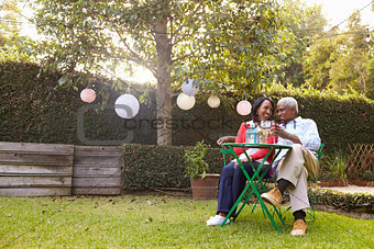Senior African American couple sitting in their back garden